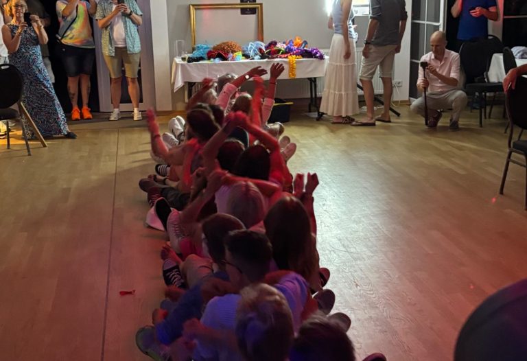Hochzeit-DJ Kremmen Hochzeitsfeier mit vielen Menschen, die auf der Tanzfläche mit bunten Lichtern versammelt sind.
