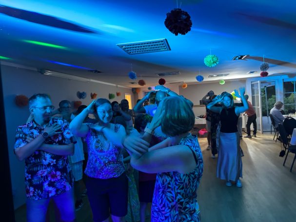 Hochzeits-Party in Grünheide bei Berlin Tanzende Menschen unter bunten Lichtern auf einer Feier.