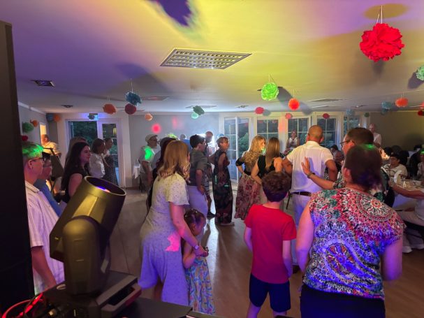 Hochzeit in Grünheide bei Berlin im Störitzland Tanzende Menschen in bunter Beleuchtung, fröhliche Stimmung bei einer Feier.