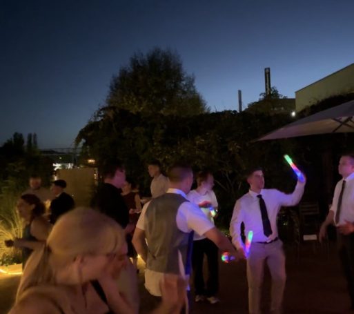 Party in Schöneweide Feiernde Menschen mit bunten Leuchtstäben bei Dunkelheit im Freien.