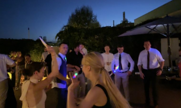 Hochzeits-Party in Schöneweide Feiernde Menschen bei Nacht, umgeben von Lichtern und einer festlichen Atmosphäre.