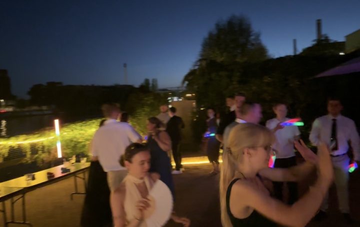 White Spreelounge Hochzeitsparty Gesellige Menschen bei Nachtfeier, mit bunten Lichtern und entspannter Atmosphäre.